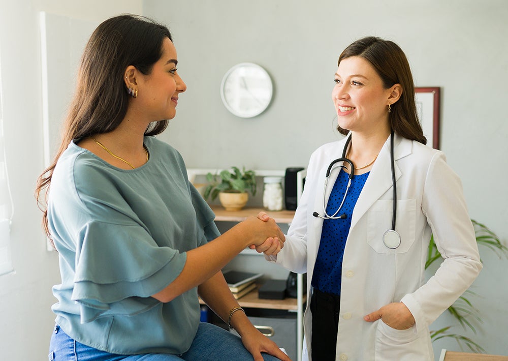 Doctor and patient shaking hands in exam room